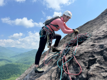Female rock climber flaking rope for their next pitch